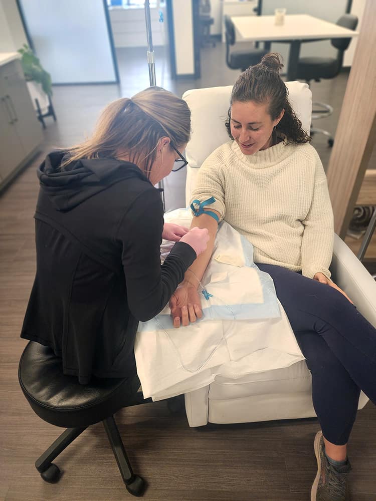 Terra Heit, Assistant Medical Director at Peak Vitality, places an IV on a patient